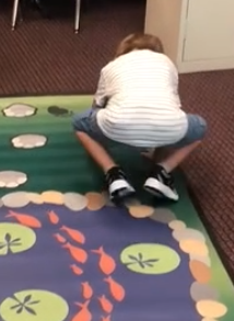child pretending to be a bear on a sensory path